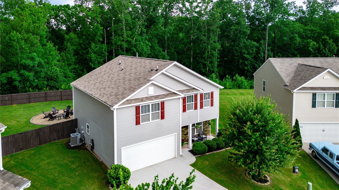 34 Karkinnen Court Pendleton, SC 29670 - Photo 32 of 36 A well-maintained suburban residence with a neatly manicured lawn and a cozy backyard fire pit area.