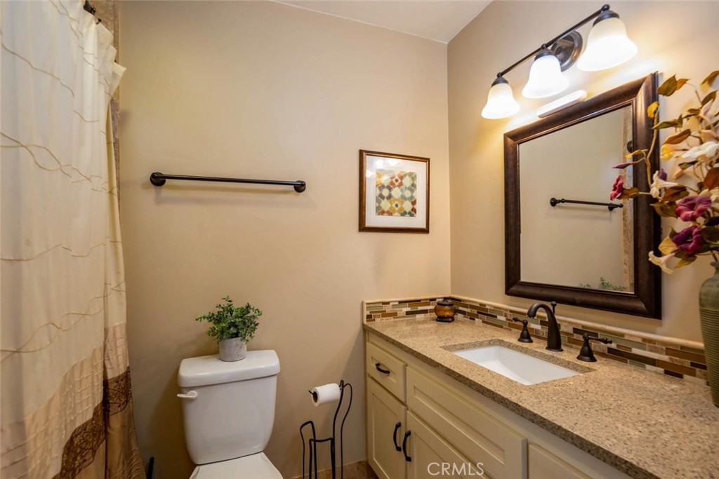 2138 Wilton Drive Cambria, CA 93428 - Photo 20 of 37 a bathroom with a granite countertop sink mirror vanity and toilet