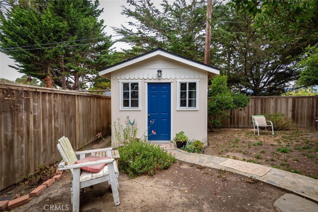 2138 Wilton Drive Cambria, CA 93428 - Photo 36 of 37 a view of a small house in the backyard with large tree and wooden fence