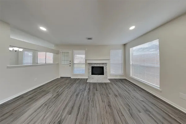 an empty room with wooden floor and a fireplace