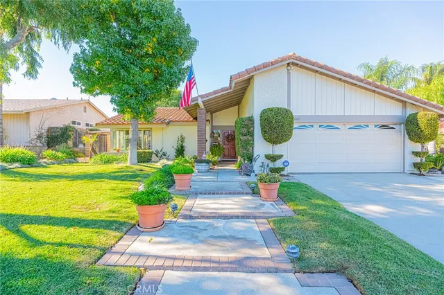 a front view of a house with fountain and potted plants
