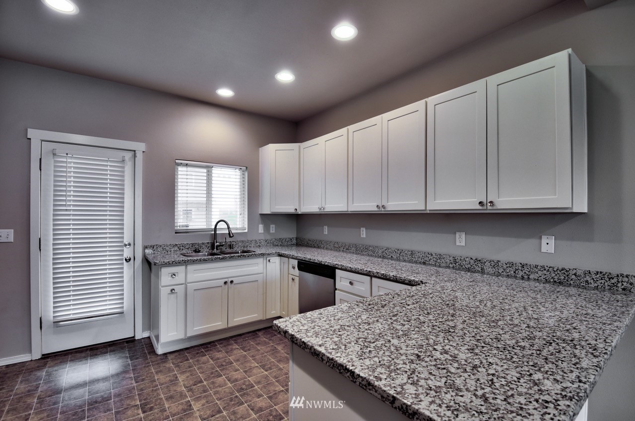 5305 Military Road East, Unit G Tacoma, WA 98446 - Photo 4 of 22 a kitchen with stainless steel appliances granite countertop a sink stove and cabinets
