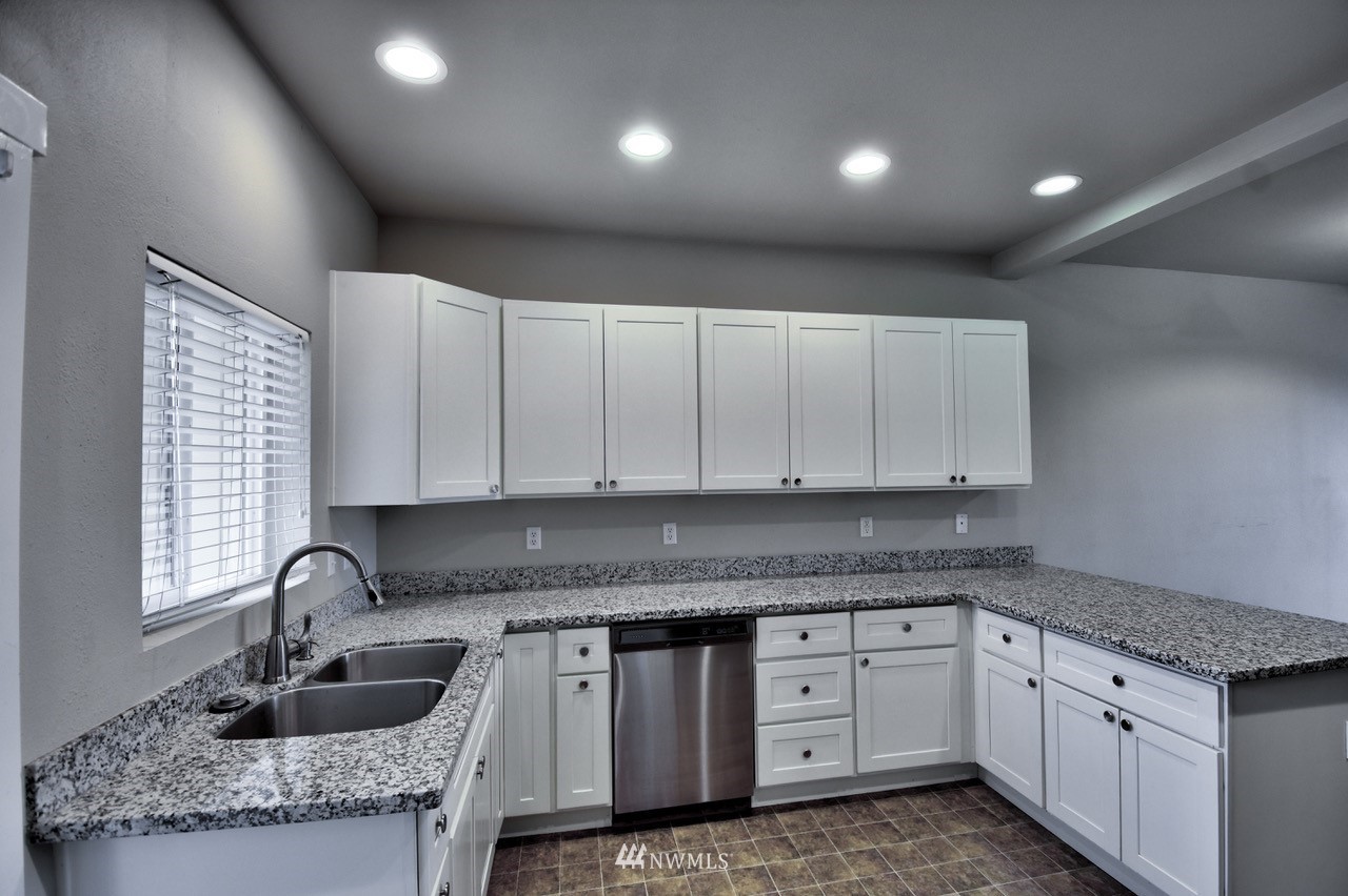 5305 Military Road East, Unit G Tacoma, WA 98446 - Photo 5 of 22 a kitchen with granite countertop a sink and cabinets