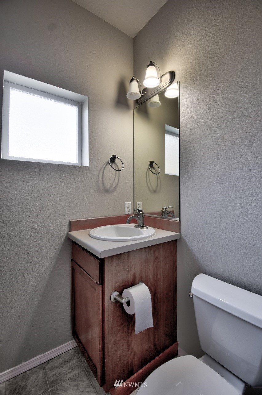 5305 Military Road East, Unit G Tacoma, WA 98446 - Photo 8 of 22 a bathroom with a toilet sink and mirror