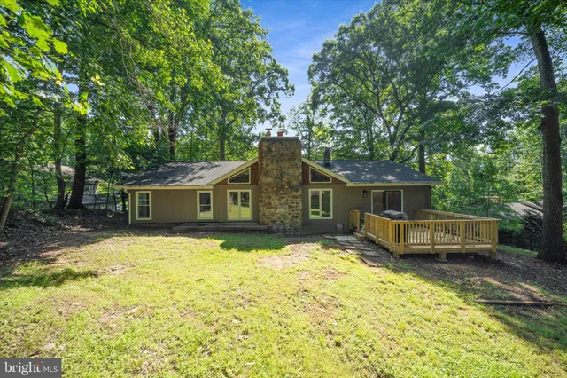 a large kitchen with a large counter top a sink stainless steel appliances and cabinets