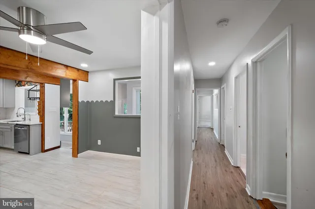 an empty room with windows and ceiling fan