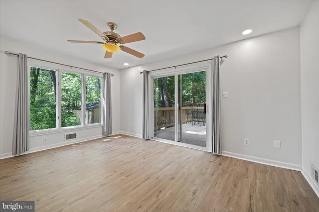 an empty room with wooden floor and furniture