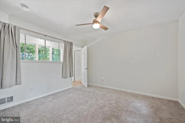 a view of an empty room with wooden floor and windows