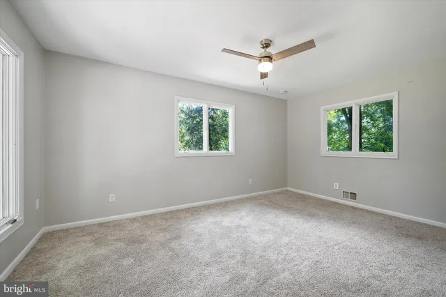 a view of an empty room with wooden floor and closet