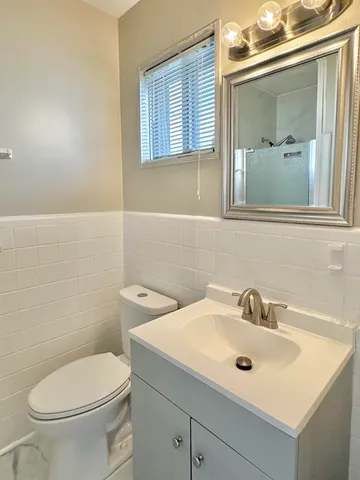 a bathroom with a sink a toilet and mirror