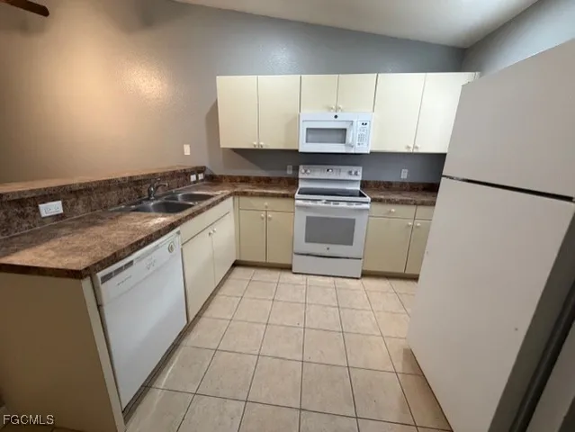 a kitchen with a sink a stove top oven and white cabinets