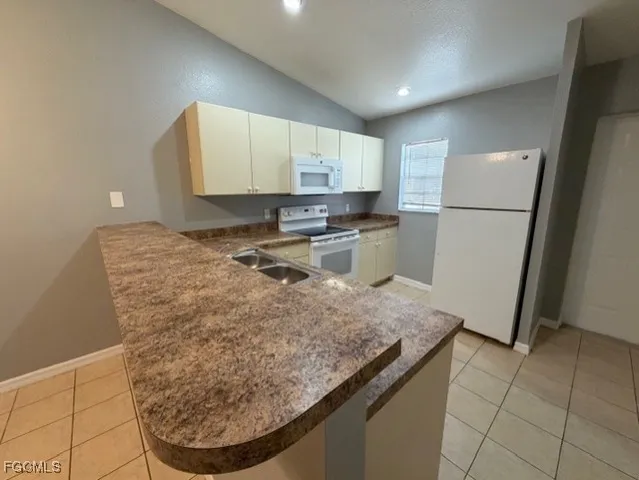 a kitchen with a sink a refrigerator and cabinets
