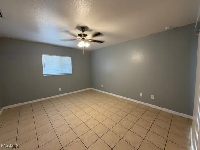 a view of an empty room and chandelier fan