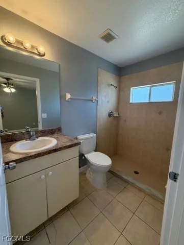 a bathroom with a granite countertop sink a toilet and a mirror