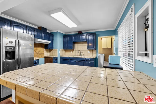 a kitchen with stainless steel appliances a refrigerator sink and cabinets