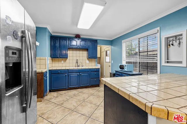 a kitchen with stainless steel appliances kitchen island granite countertop a refrigerator and a stove top oven