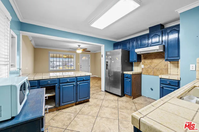 a kitchen with stainless steel appliances granite countertop a stove refrigerator and cabinets