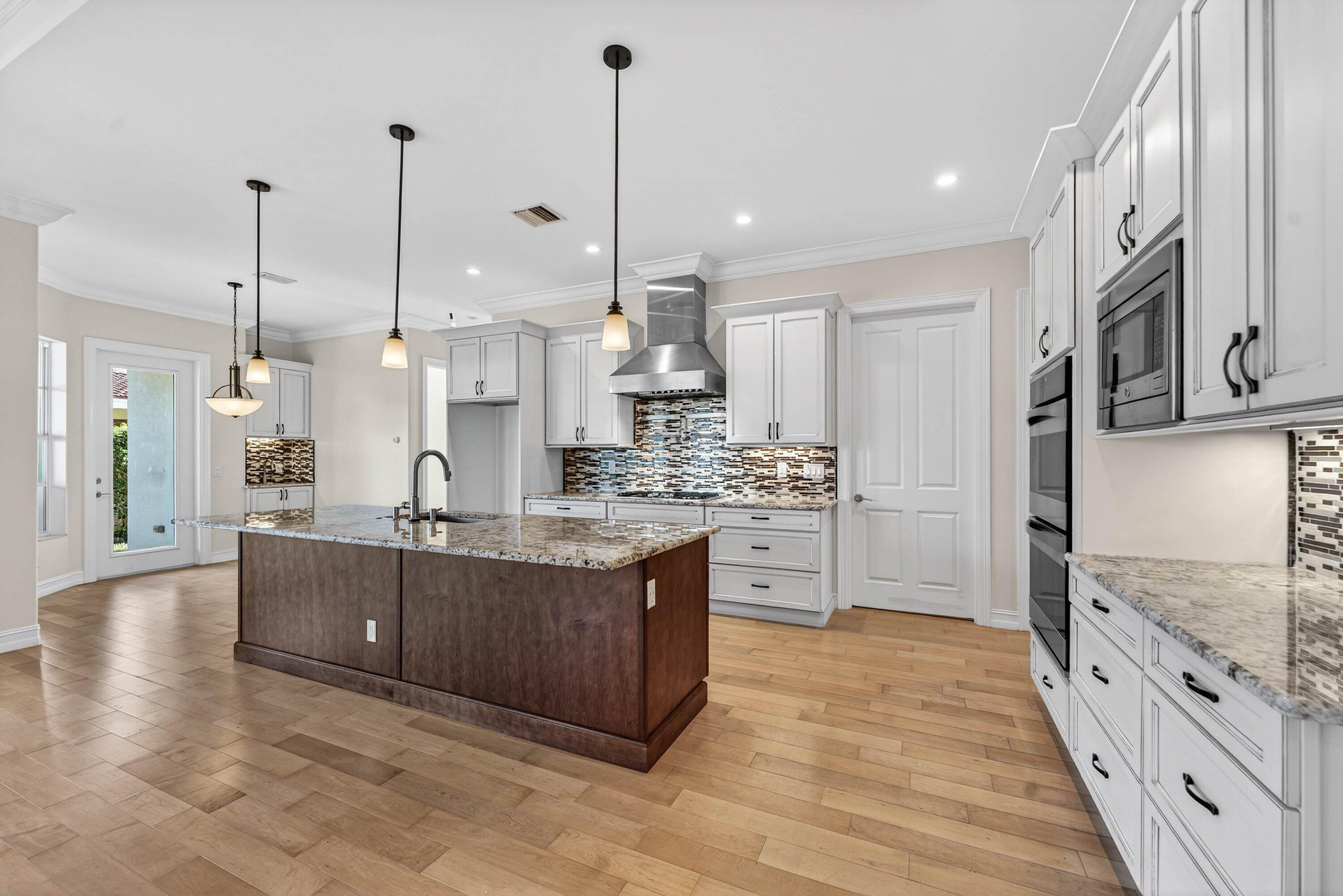 2920 Spanish River Road Boca Raton, FL 33432 - Photo 20 of 75 a large kitchen with stainless steel appliances kitchen island granite countertop a stove a sink and white cabinets