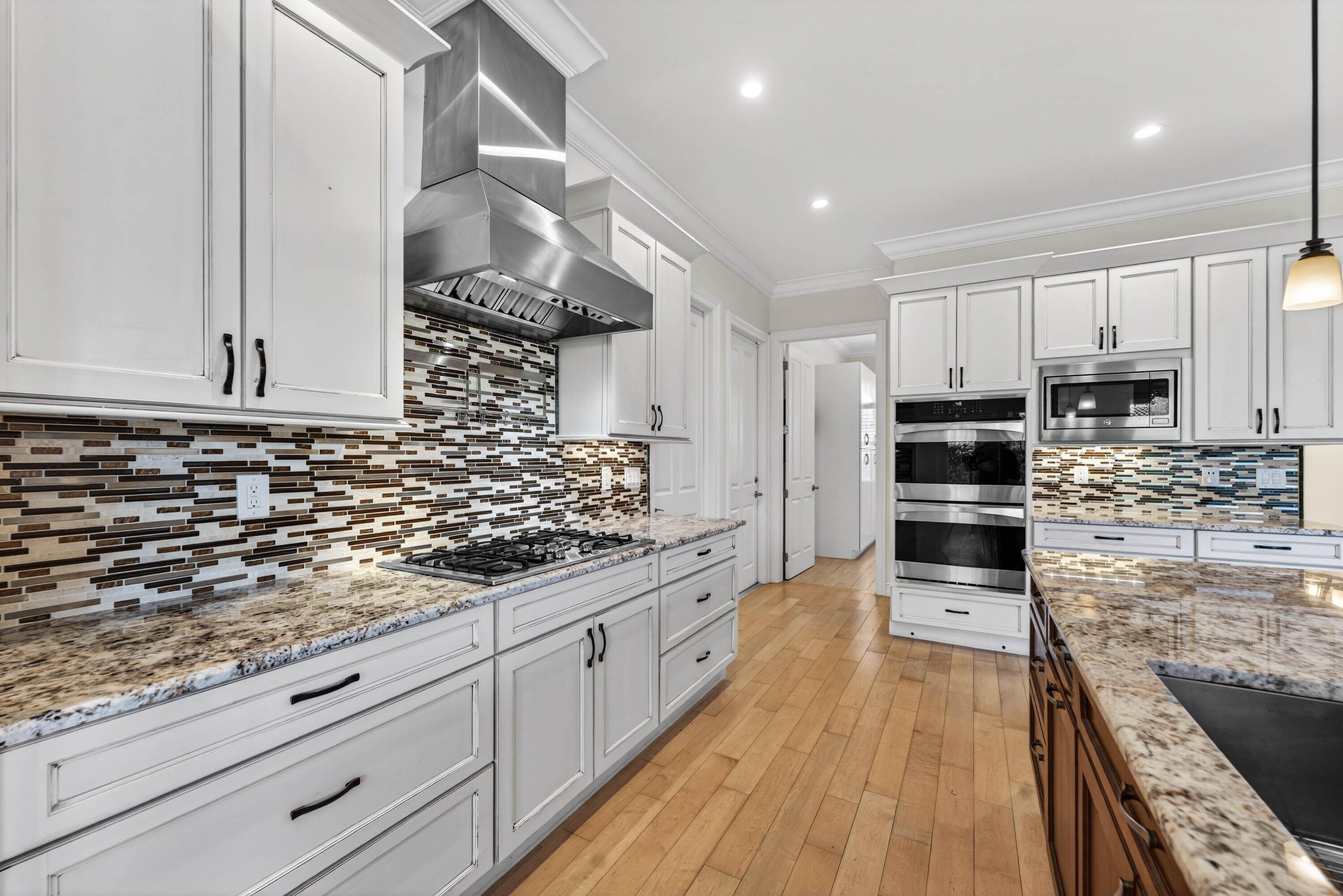 2920 Spanish River Road Boca Raton, FL 33432 - Photo 23 of 75 a kitchen with stainless steel appliances kitchen island granite countertop a stove a sink and white cabinets