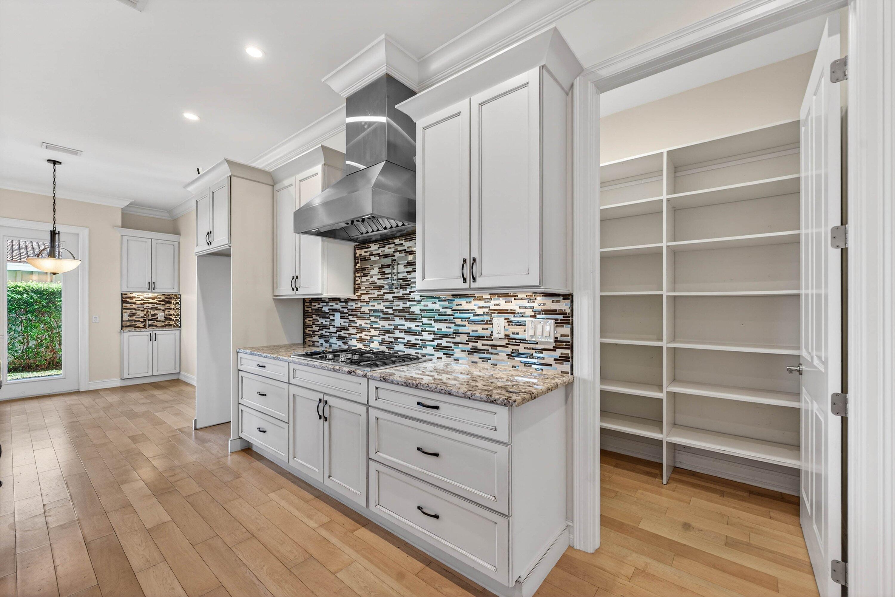 2920 Spanish River Road Boca Raton, FL 33432 - Photo 25 of 75 a kitchen with stainless steel appliances granite countertop a stove and a wooden floors