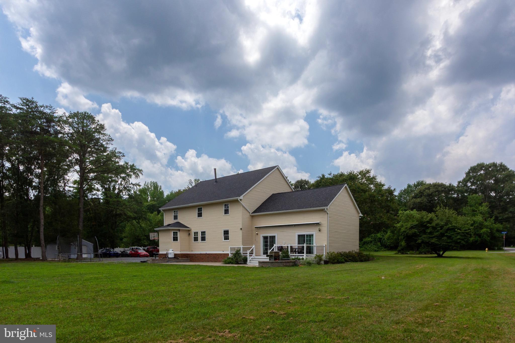 911 South Wieker Road Severn, MD 21144 - Photo 14 of 73 a white house with a big yard and large trees