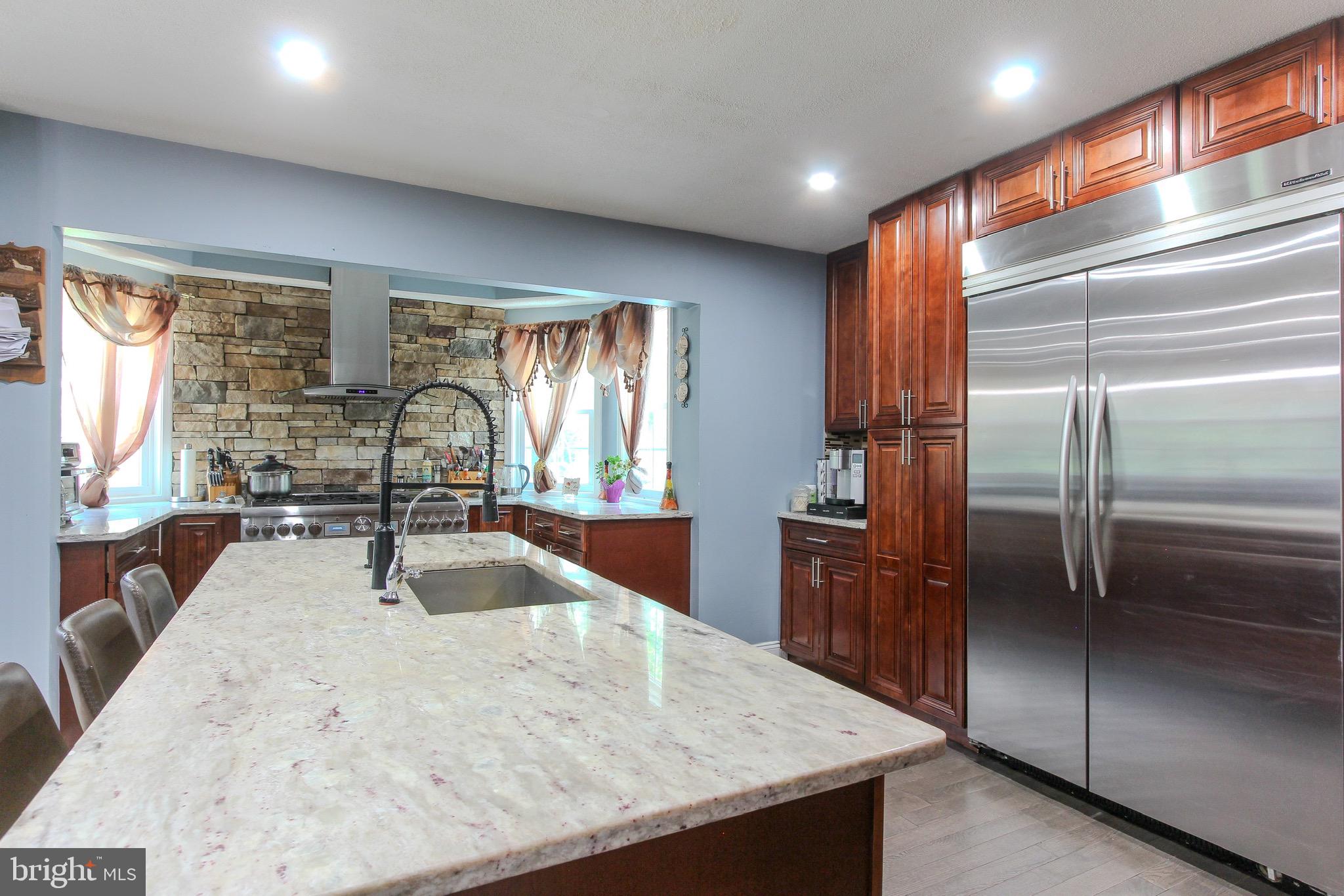 911 South Wieker Road Severn, MD 21144 - Photo 35 of 73 a kitchen with stainless steel appliances granite countertop a refrigerator a sink a stove and island