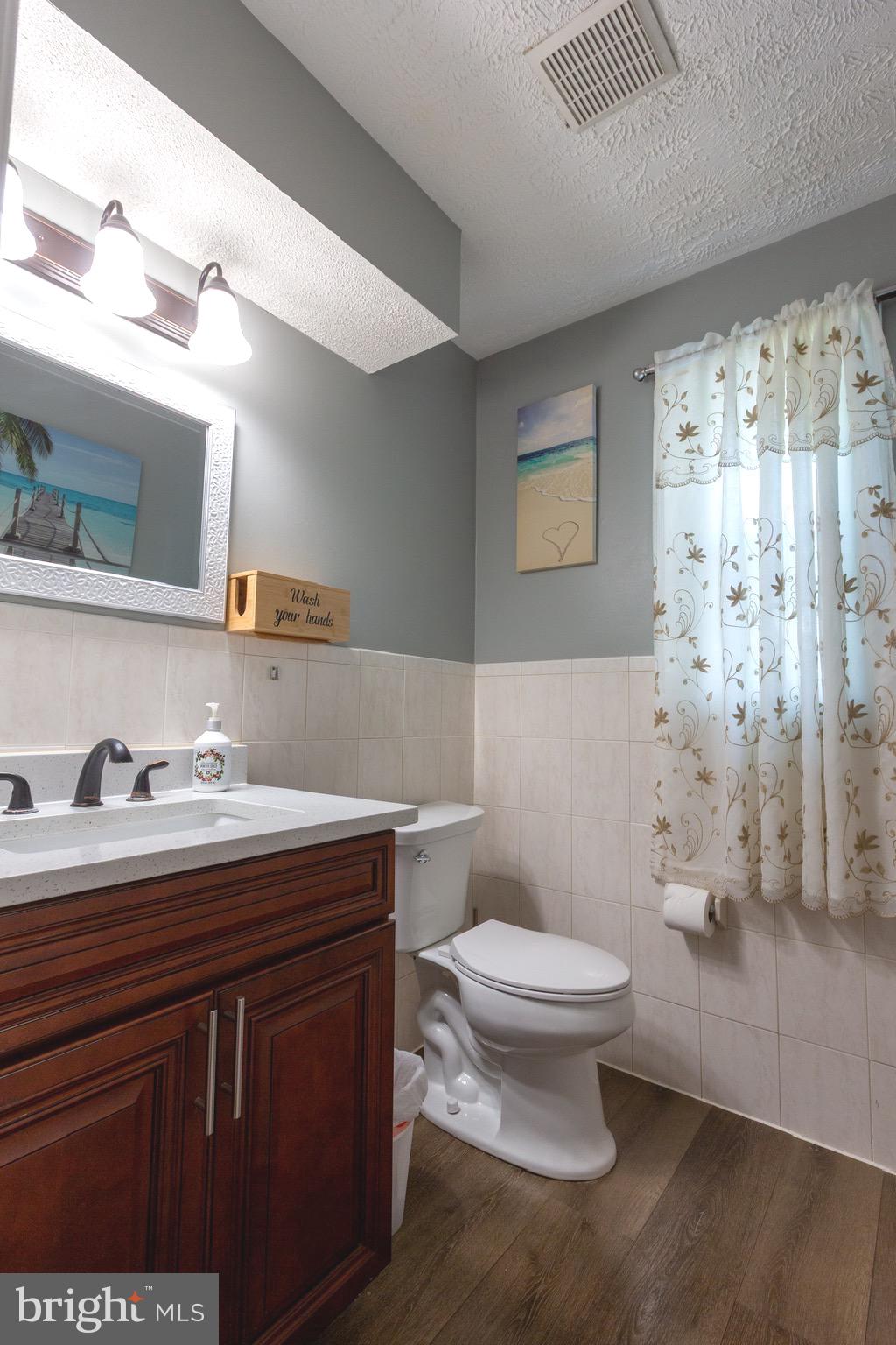911 South Wieker Road Severn, MD 21144 - Photo 41 of 73 a bathroom with a granite countertop sink a toilet and a mirror