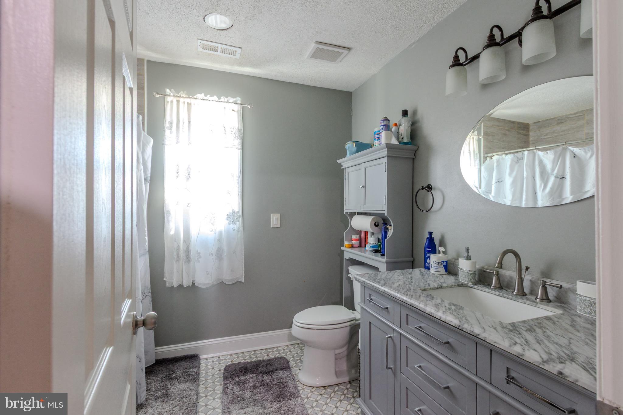 911 South Wieker Road Severn, MD 21144 - Photo 43 of 73 a bathroom with a granite countertop sink toilet and mirror