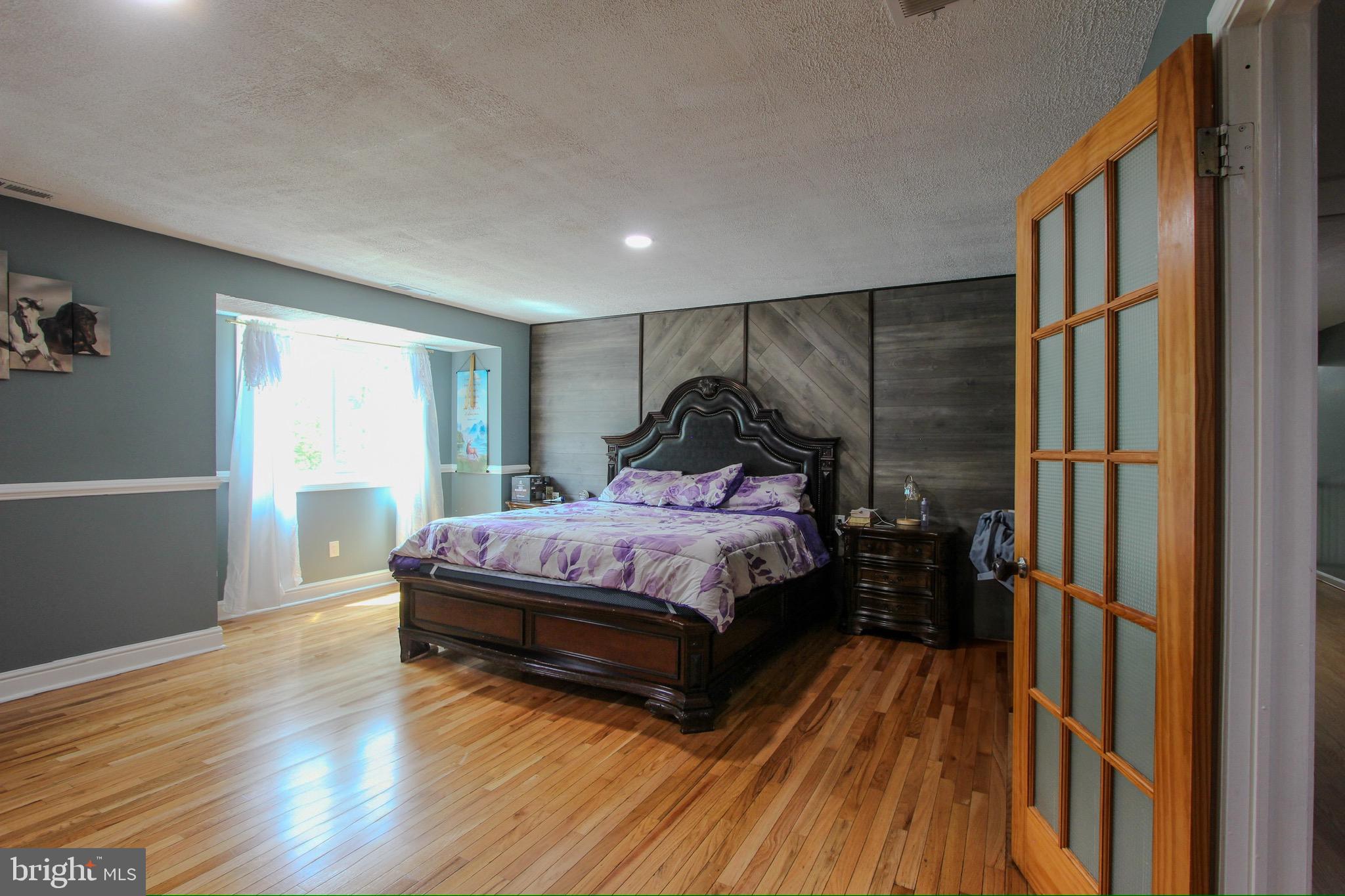 911 South Wieker Road Severn, MD 21144 - Photo 49 of 73 a bedroom with a bed and wooden floor