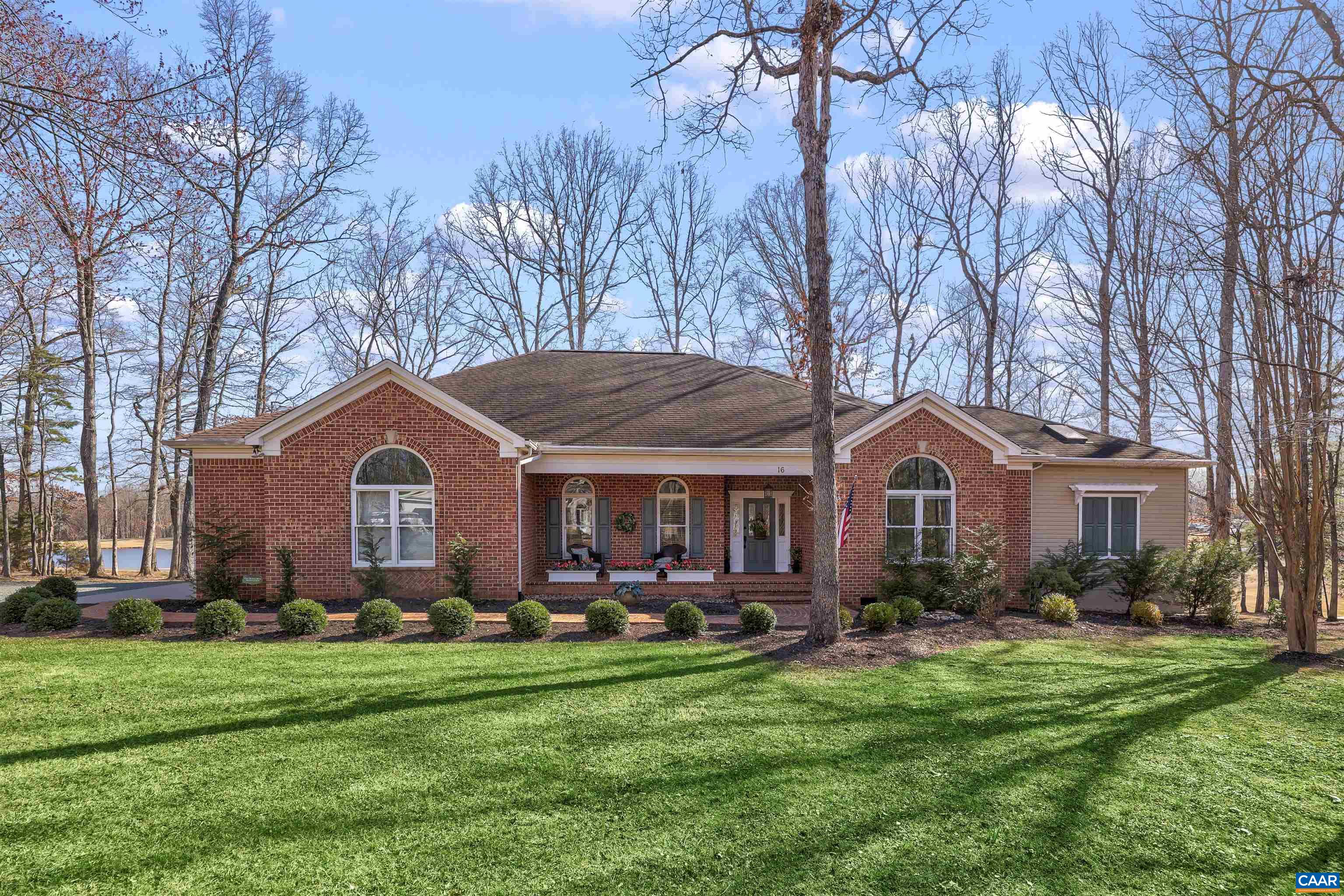 a front view of a house with a yard and trees