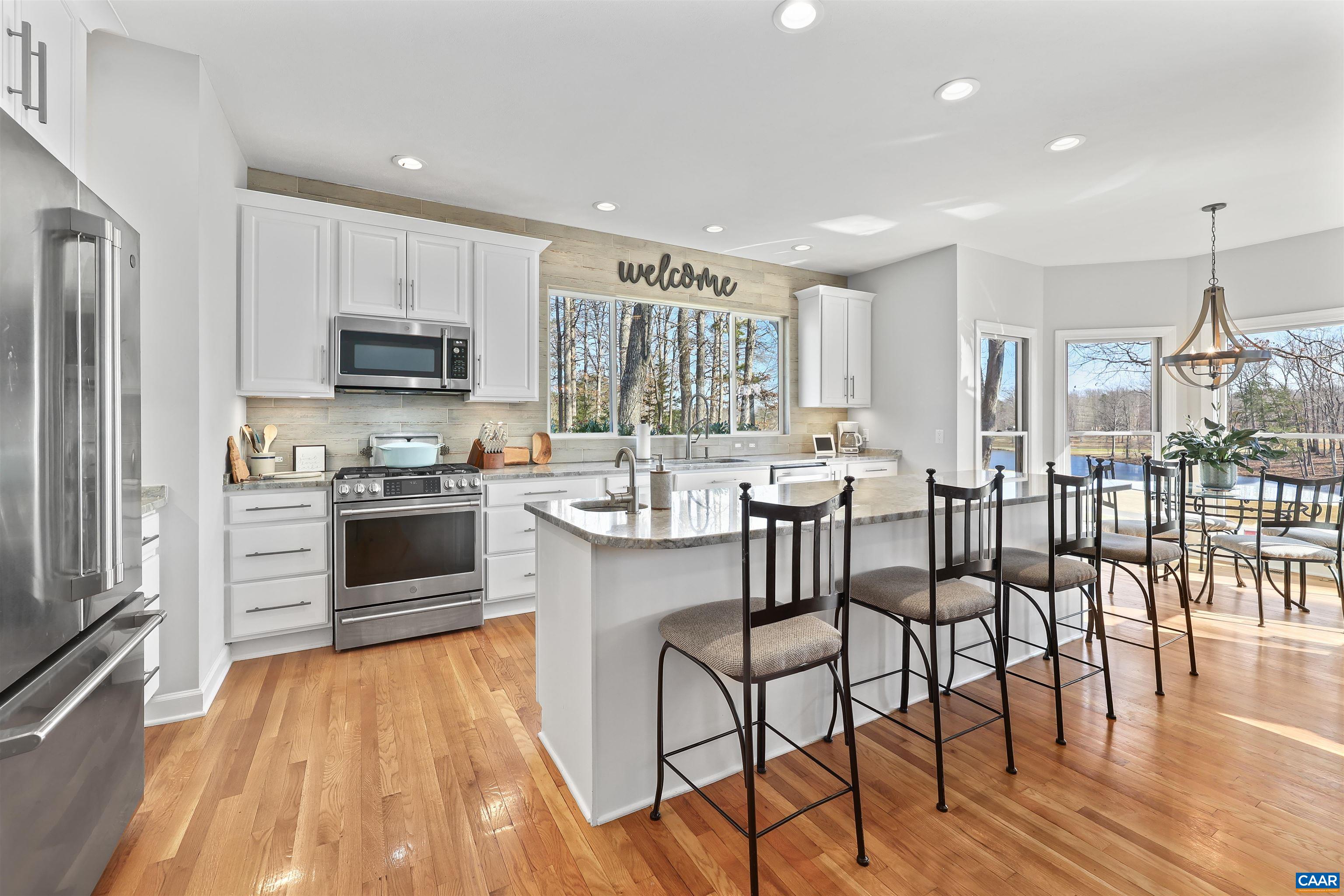 16 Oak Grove Road Palmyra, VA 22963 - Photo 17 of 53 a kitchen with stainless steel appliances a dining table chairs refrigerator and cabinets