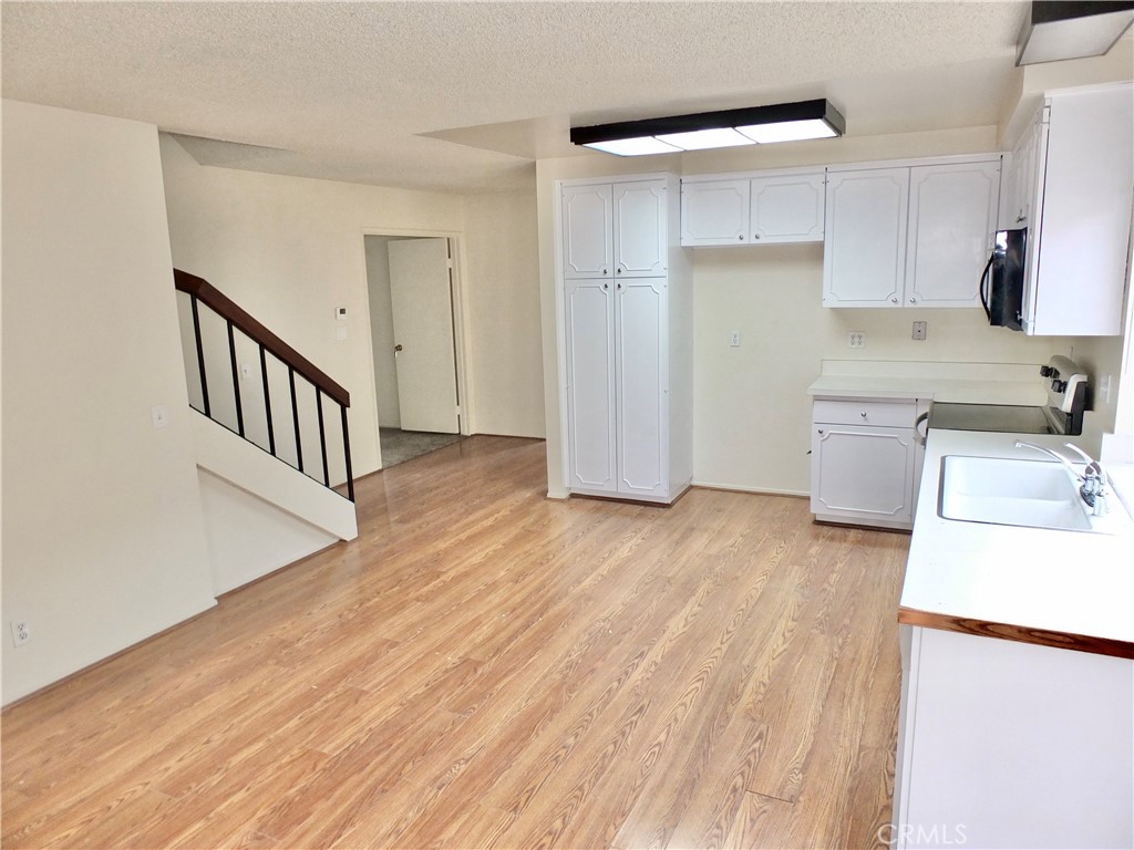 14431 Raintree Road Tustin, CA 92780 - Photo 19 of 53 a view of a kitchen with a sink and dishwasher wooden floor