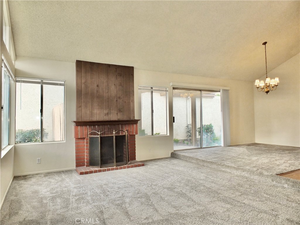 14431 Raintree Road Tustin, CA 92780 - Photo 4 of 53 a view of an empty room with a fireplace and a window