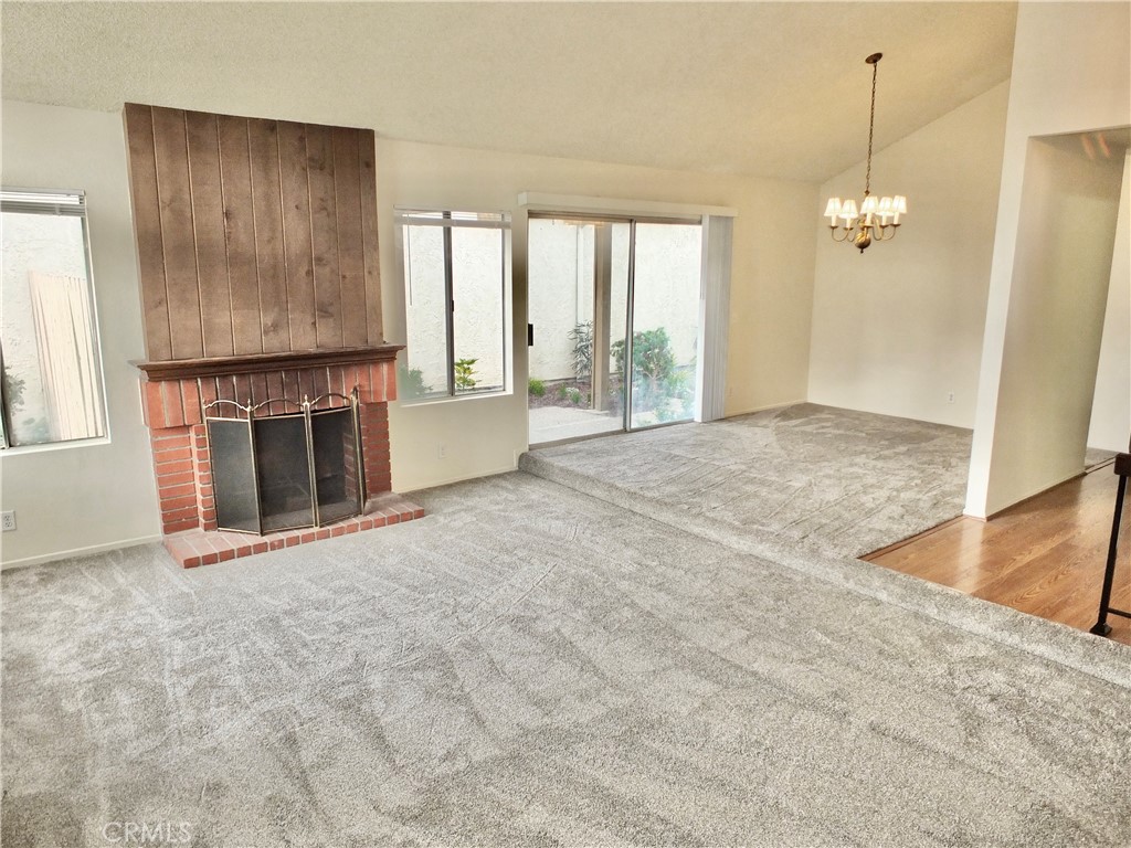 14431 Raintree Road Tustin, CA 92780 - Photo 6 of 53 a view of an empty room with a fireplace and a window