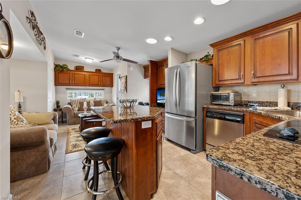 1515 Ruby Lake Point Naples, FL 34114 - Photo 14 of 21 a kitchen with stainless steel appliances granite countertop a refrigerator stove microwave and sink