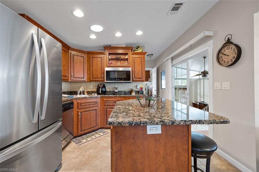 1515 Ruby Lake Point Naples, FL 34114 - Photo 17 of 21 a kitchen with stainless steel appliances granite countertop a refrigerator a stove and a sink with large countertops