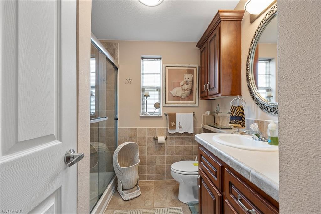 1515 Ruby Lake Point Naples, FL 34114 - Photo 19 of 21 a bathroom with a granite countertop toilet sink and mirror