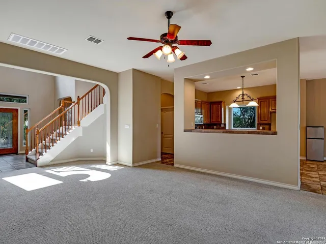 a view of entryway and hall with a chandelier fan