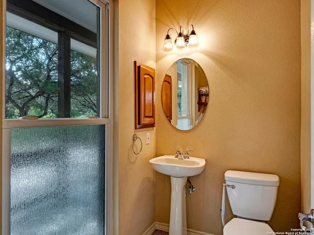 a bathroom with a toilet sink and mirror