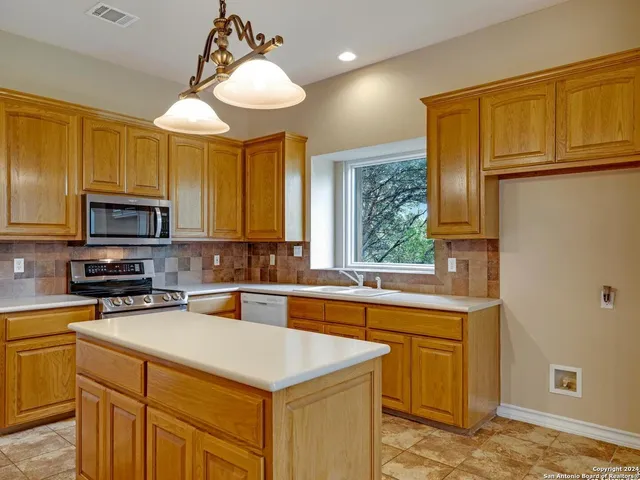 a kitchen with a sink a stove and cabinets