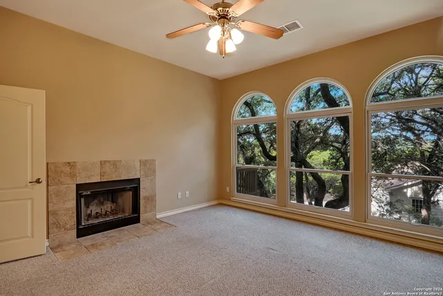 an empty room with windows and a fireplace