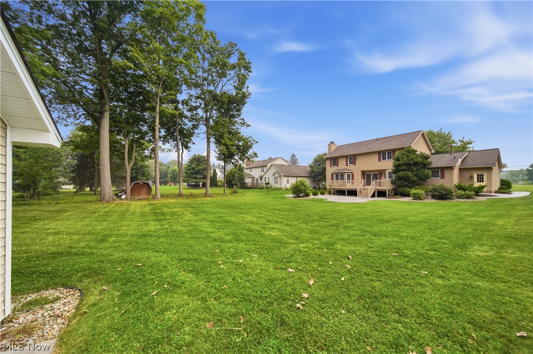 4764 Young Road Stow, OH 44224 - Photo 41 of 41 Expansive green lawn with mature trees and a two-story home featuring a ground-level deck, upper-level balcony, and a multi-level roofline