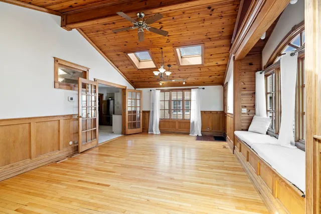 a view of a hall with wooden floor and windows
