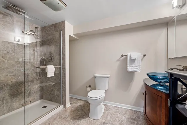 a bathroom with a shower a toilet and a sink