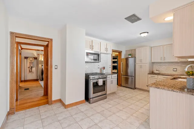 a kitchen with stainless steel appliances granite countertop a refrigerator and a stove top oven