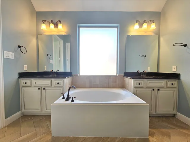 a bath tub sitting in a bathroom and mirror