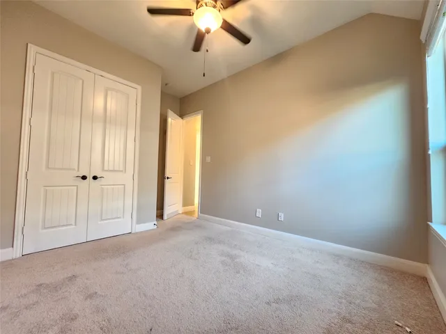 en empty room with windows and fan