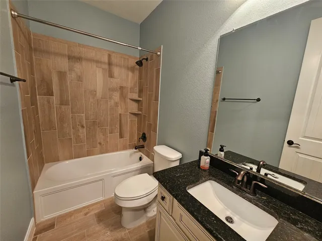 a bathroom with a double vanity sink toilet mirror and shower