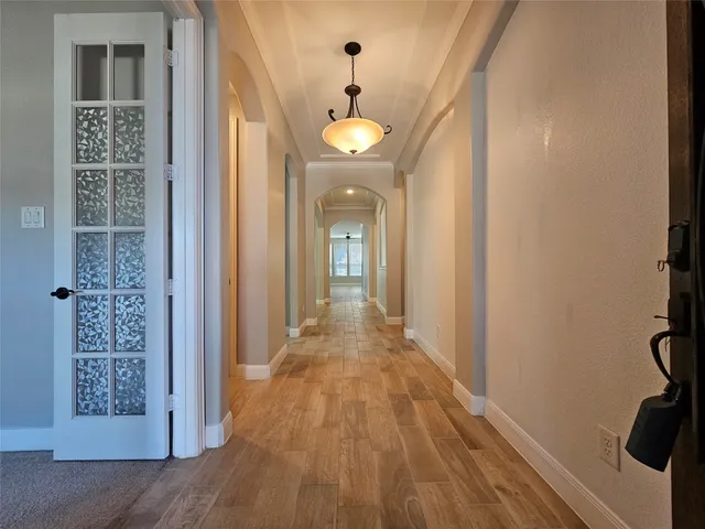a view of a hallway with wooden floor and staircase