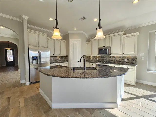a kitchen with stainless steel appliances granite countertop a sink a counter top space cabinets and wooden floor
